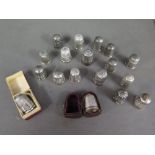 A collection of thirteen silver thimbles and five plated thimbles