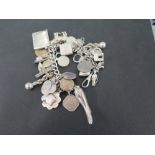 A silver charm bracelet - The curb-link converted Albert suspending assorted clasp, with toggle