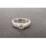 An 18ct gold diamond ring - The brilliant-cut diamond to the similarly-cut diamond shoulders and