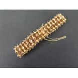 A fancy-link woven bracelet - With bead detail - Stamped 750 - Length 19cms - Weight approx