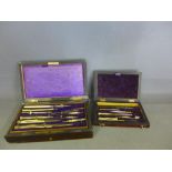 Two boxed Geometry sets - both rosewood cased - large set with ivory handled pen, boxwood rule etc.