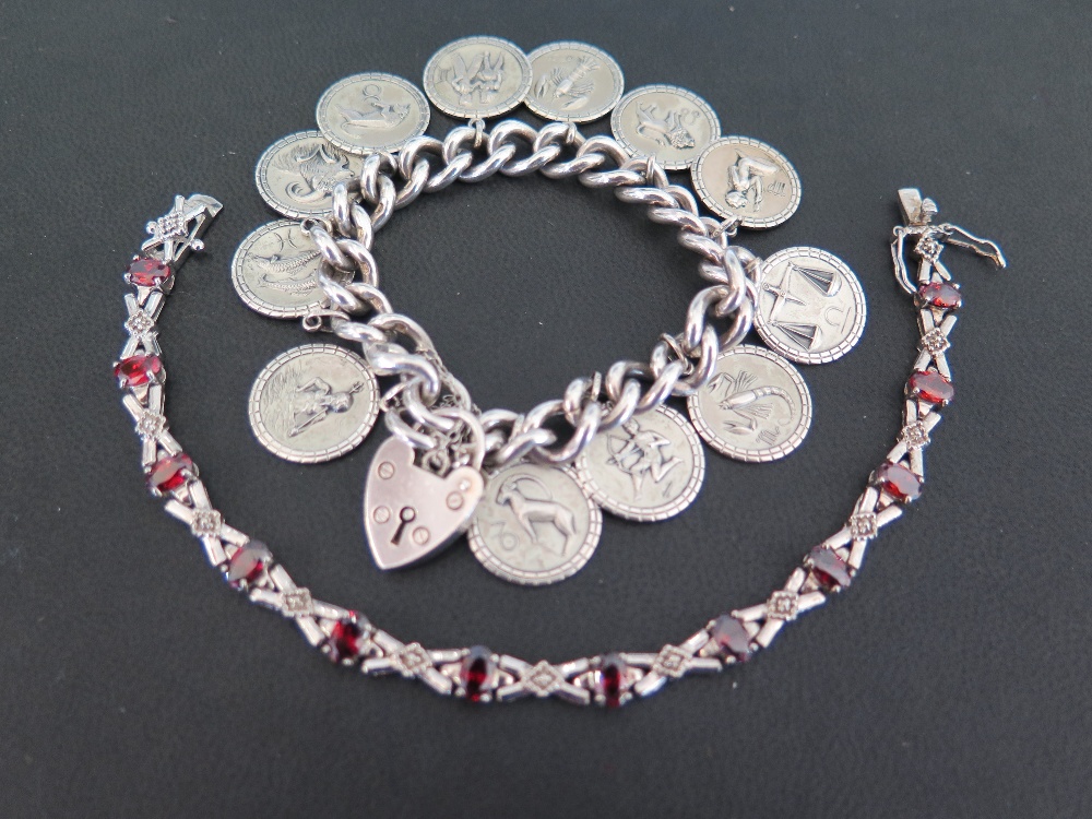 A silver curb-link bracelet - Suspending a series of charms depicting the signs of the zodiac -
