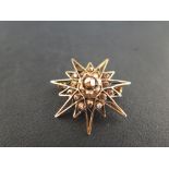 A smaller star brooch/pendant - with faceted bead detail - Tests as 18ct gold - Diameter  3.2cms -