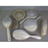 A collection of three silver backed dressing table mirrors and three brushes
Condition report: Wear