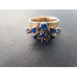 An unusual gold and sapphire five band ring each band set with a claw set sapphire - size K -