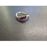 An 18ct gold ruby and diamond dress ring - To the asymmetric shoulders and plain band - Hallmarked