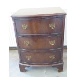 A small mahogany bowfront chest of three long drawers raised on bracket supports - 55 cm x 43 cm x