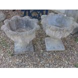 A pair of reconstituted stone planters with foliate decoration - 47cm high x 47cm diameter