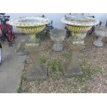 A pair of white painted metal planters 34cm high x 54cm diameter raised on reconstituted stone