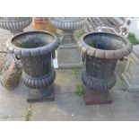 A pair of large black painted metal garden planter urns with foliate design and ring handles 78cm