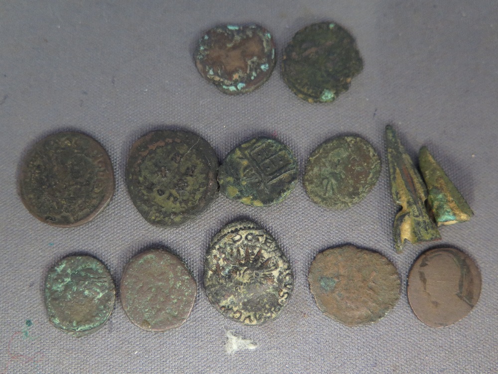 Eleven Roman bronze coins and two arrow heads