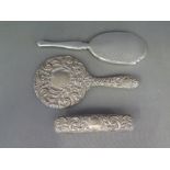 Two silver hallmarked hand mirrors, one with embossed decoration,