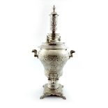 A large electroplated samovar, baluster form, embossed foliate scroll decoration, on a raised square