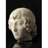 A classical carved marble portrait bust of a boy, with almond eyes and thick curling hair,