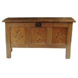 An oak chest, the top with later hinges the interior originally with a till, the triple panelled