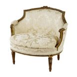 A Louis XVI style giltwood bergère, with a carved flower crest above leaf capped scroll arms and
