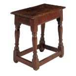 A 17th century joined oak stool, the seat with a moulded edge on baluster turned and block