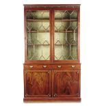 A 19th century mahogany bookcase cabinet, the detachable fluted cornice with carved paterae