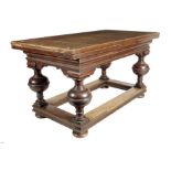A Flemish oak draw leaf dining table in 17th century style, the moulded frieze above turned legs