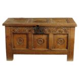 An early 18th century oak triple panelled chest, the interior with a till, the front carved with