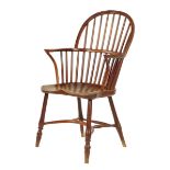 A Victorian yew low back Windsor armchair, with an elm seat on turned legs united by a crinoline