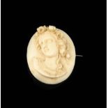 λ A Victorian carved ivory brooch, of a bust of a young lady with flowers in her hair, 4.8cm high.