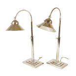 A pair of nickel plated desk lamps, with adjustable stems and heads, each on a stepped base, modern,