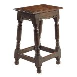 A joined oak stool, the moulded edge top above carved fret friezes on turned supports united by