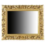 An Italian Florentine giltwood wall mirror, the rectangular plate to a leaf scroll carved frame,