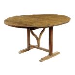 A 19th century French oak vendange table, the circular boarded tilt-top on a bow support and