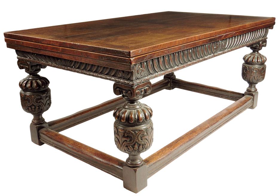 A late 19th century oak draw leaf dining table in Jacobean style, the panelled top above a carved