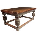 A late 19th century oak draw leaf dining table in Jacobean style, the panelled top above a carved