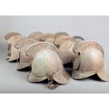 Nine brass firemans helmets, with cast crestings and another leather helmet, badges lacking and