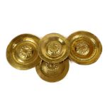 Four German brass alms dishes, each with a punch decorated outer rim and with a central whorl,