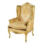 A Louis XV style giltwood bergère, the moulded frame carved with scrolls, flowers and leaves on