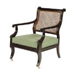 An early 19th century ebonized open armchair, with a cane back and seat to a moulded frame with a