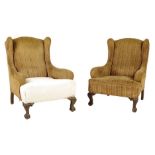 A pair of mahogany wing armchairs in George II style, on leaf capped cabriole front legs and claw