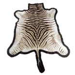 A zebra skin rug, with a black felt backing, 268 x 200cm.