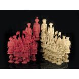 λ A late 19th century Chinese Canton carved ivory figural chess set, with puzzle ball bases, natural