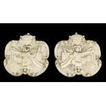 A pair of carved and painted wood plaques, each carved with classical urn above a cartouche