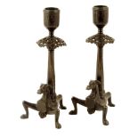 A pair of 19th century bronze candlesticks in Renaissance style, each with a pierced canopy above