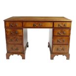 A mahogany twin pedestal desk in George III style, the moulded edge top inset a gilt tooled