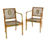 A pair of satinwood Sheraton revival open armchairs, each with a cane back and seat and with an oval