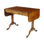 A walnut sofa table in Regency style, the reeded edge drop-flap top above a frieze drawer on trestle