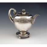 λ A George III silver teapot, by Emes and Barnard, London 1809, circular form, chased vine leaf
