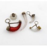A small collection of four silver-mounted horn shape scent bottles, comprising: one with a red glass