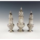 A suite of three George III silver casters, by Samuel Wood, London 1761,  fluted baluster form,