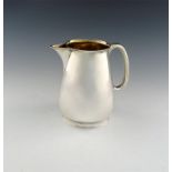 A Victorian silver water jug, by Rupert Favell, London 1886, tapering circular form, scroll