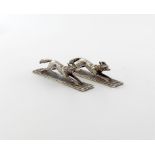 A pair of late-Victorian novelty silver running foxes knife rests, by William Hutton and Sons,