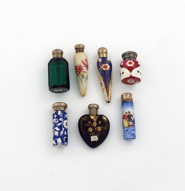 A small collection of seven silver-mounted ceramic and glass scent bottles, comprising: one of heart